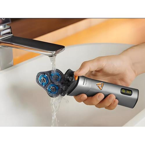 Philips 3000 Series electric shaver in grey being rinsed under a bathroom faucet to clean the 6D flex shaving heads.