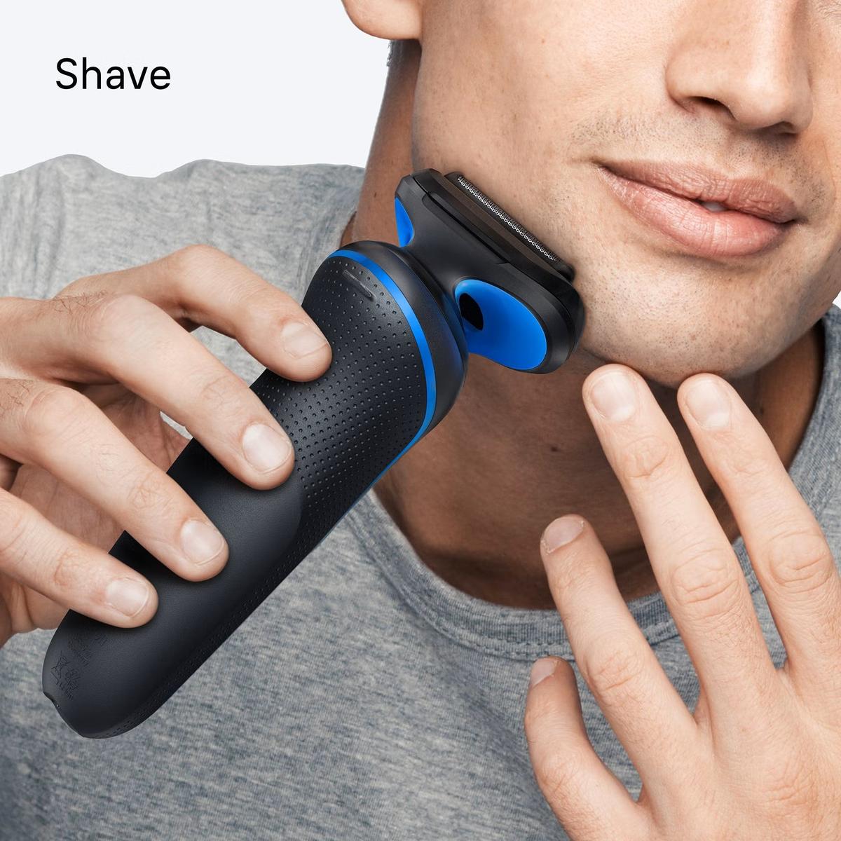 Man using a blue and black Braun Series 5 electric shaver with three flex blades on his jawline.