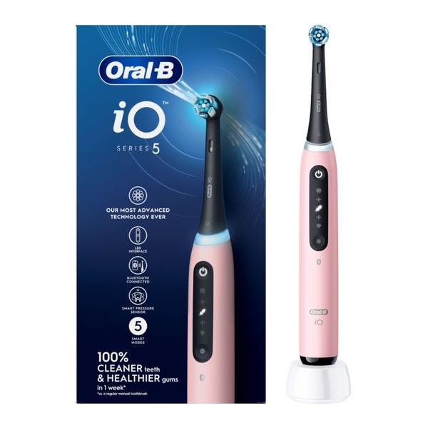 Blush pink Oral-B iO5 electric toothbrush with black handle, round brush head, and white charging base on branded box.