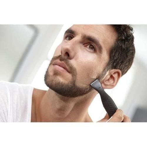Man using a black Philips Multi-Groom precision trimmer to shape his beard and sideburns for a clean, defined look.