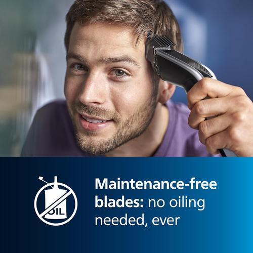 Man using a black Philips Series 5000 hair clipper with self-sharpening blades that require no oiling.