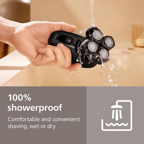 Black Philips 5000 Series head shaver being rinsed under a faucet, highlighting its waterproof design.