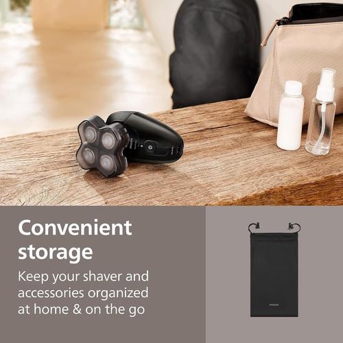 Black Philips 5000 Series head shaver with 360-degree flexing blades on a wooden surface next to a travel pouch.