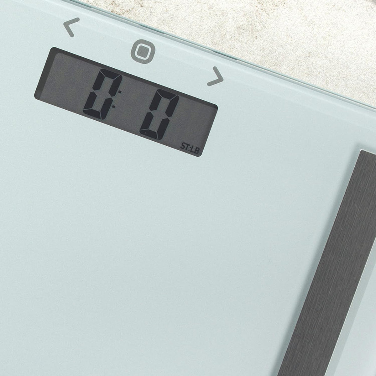 Slim silver Salter digital bathroom scale with a clear LCD display and touch-sensitive navigation buttons.